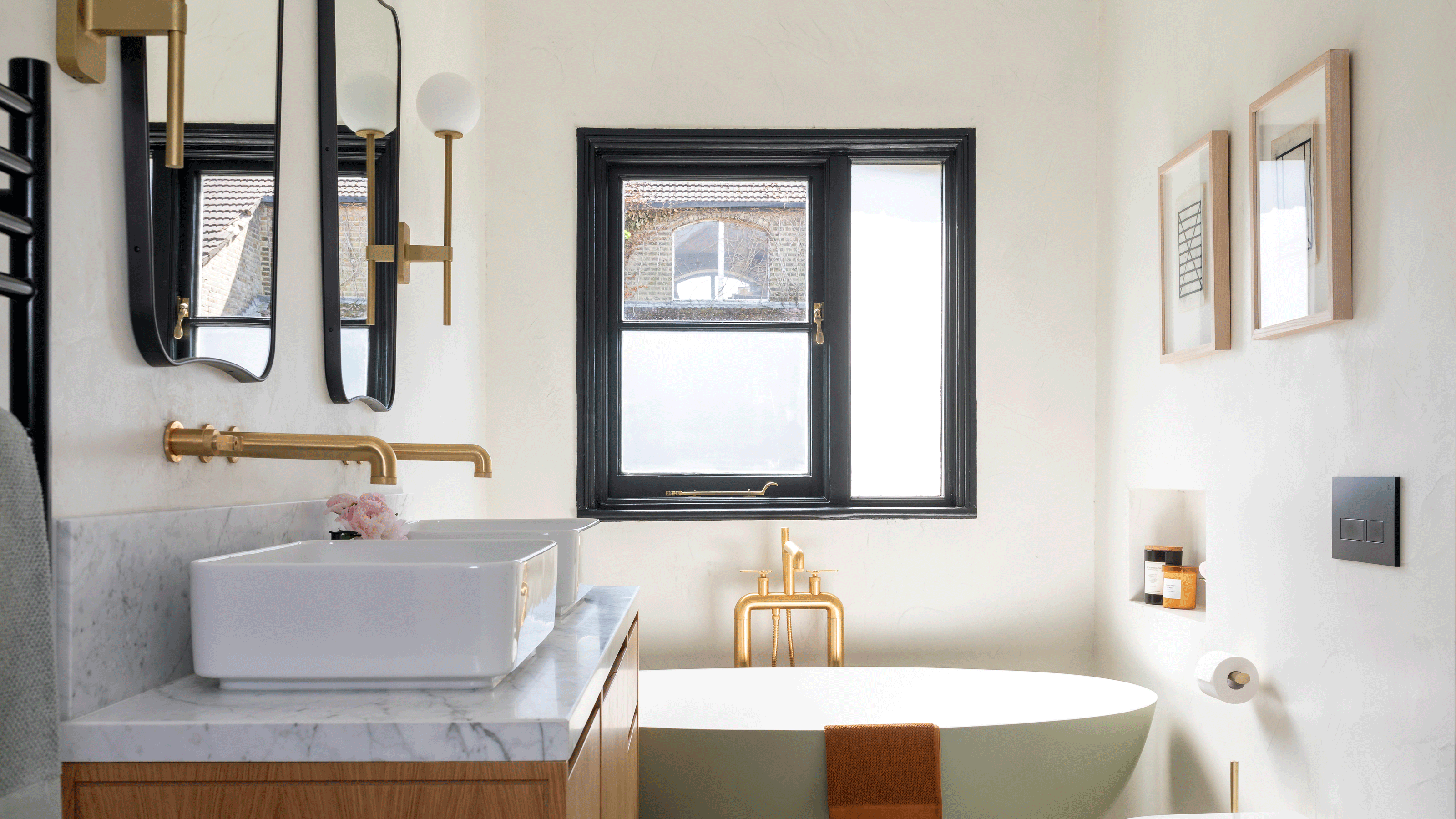 Small white bathroom with wooden floating vanity unit and large round mirror on wall 