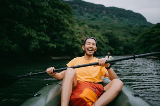 A man paddling a raft in a mangrove in Okinawa, Japan.