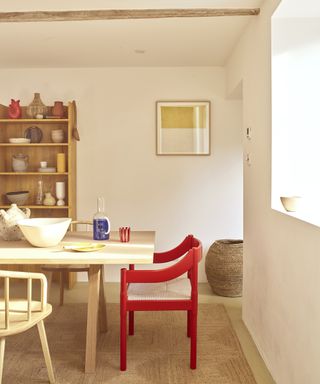 natural dining room scheme with bright red chair