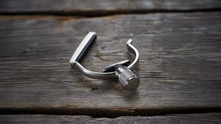 Close up on silver capo on a wooden bench