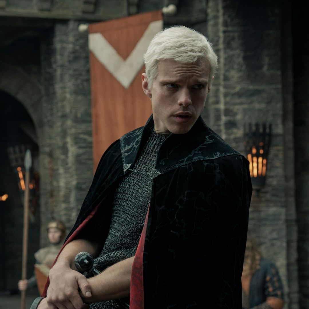 finn bennett as prince aerion targaryen riding on horseback through a medieval town in a still from a knight of seven kingdoms