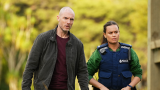 Detective Theo (Richard Flood) and DS Diana Huia (Acushla-Tara Kupe) stand side-by-side with sombre expressions as they search for a lead in their latest case in season 1 of The Gone.