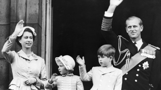 London, England: Queen Elizabeth II, Princess Anne, Prince Charles and the Duke of Edinburgh, on a balcony at Buckingham Palace, wave to crowds below May 15, 1954, after return from a tour of British possessions.