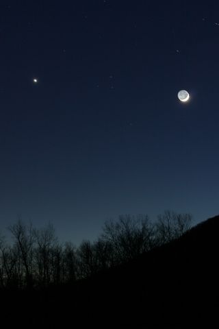 The crescent moon and Venus shine bright over the Housatonic River in Kent, Conn., on Dec. 26, 2011 during a dazzling conjunction. This photo was taken by skywatcher Scott Tully.