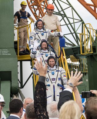 Roscosmos cosmonaut Sergei Prokopyev (bottom, NASA astronaut Serena Auñón-Chancellor (center) and European Space Agency astronaut Alexander Gerst say farewell to Earth as they prepare to board their Soyuz MS--09 spacecraft for a launch from Baikonur Cosmodrome, Kazakhstan on June 6, 2018. The trio is headed to the International Space Station.