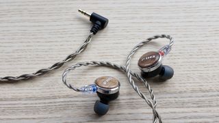 FiiO FP3 wired earbuds on a wooden surface