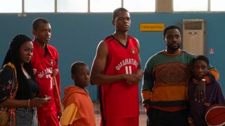 A family stands on a basketball court together