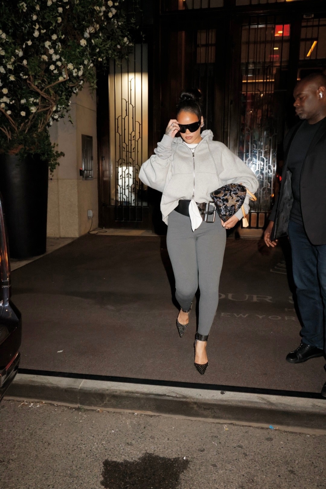 Rihanna wears gray sweats paired with a sold-out Louis Vuitton emblem bag covered in velvet and sequins