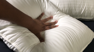 Hand pressed into a white pillow