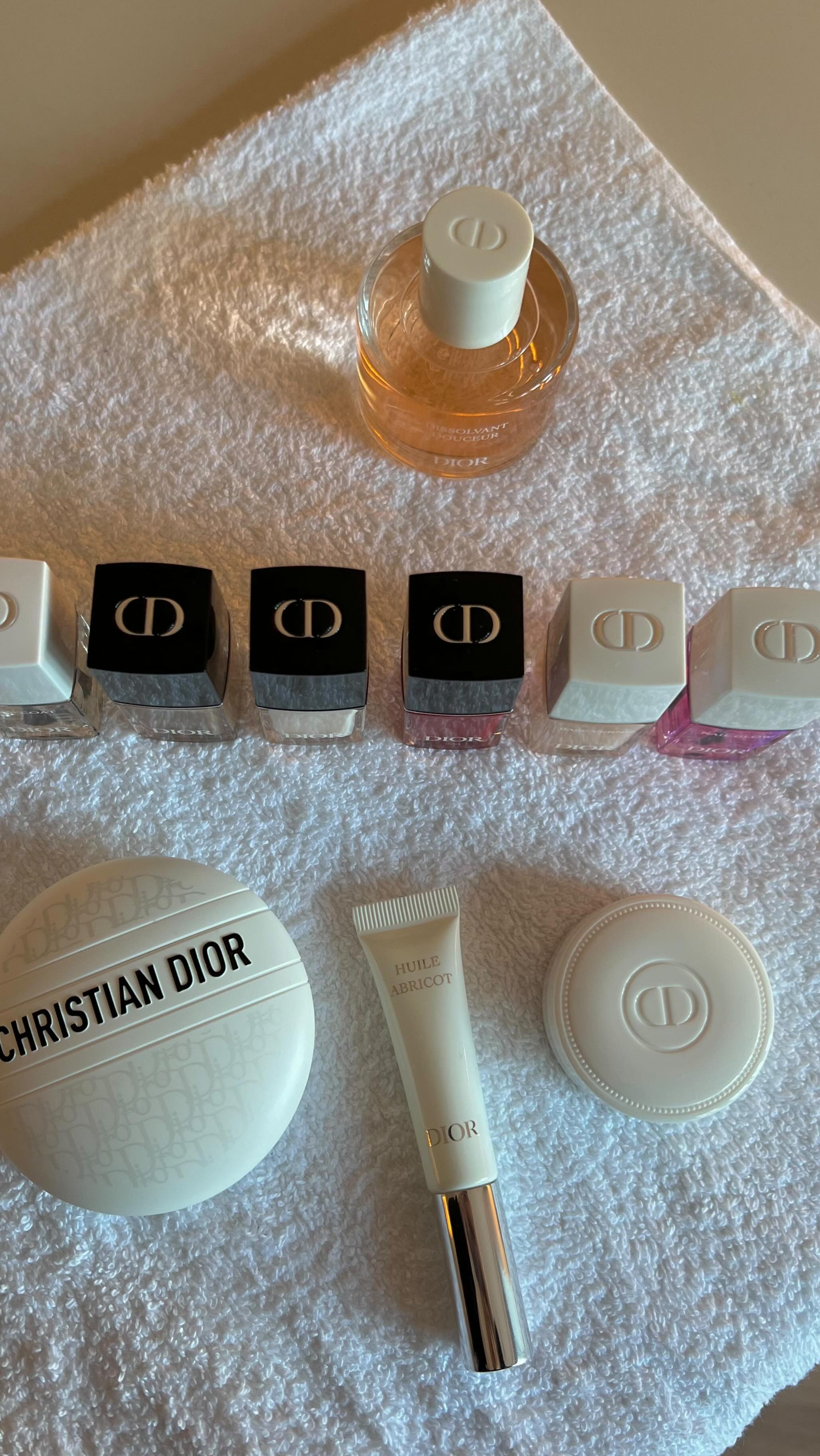 A nail tech set-up with nail care proeducts and polishes on a white towel