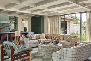 living room with detailed ceiling, eclectic sofas and green kitchen