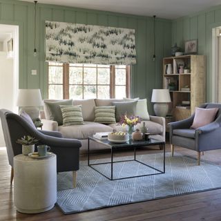 Grey sofa in a green wood panelled room