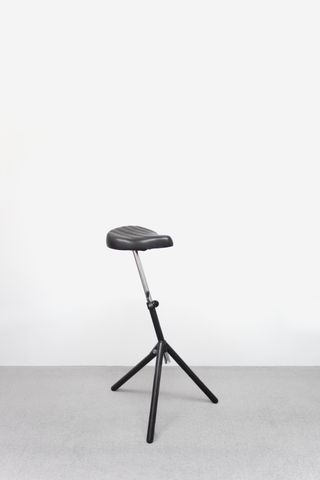 A vintage stool by IKEA featuring a black leather bike seat on a black tripod structure