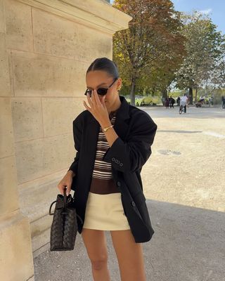 Woman wearing yellow miniskirt and oversize blazer.