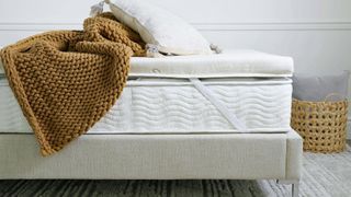 The Saatva Graphite Memory Foam Mattress Topper on a bed