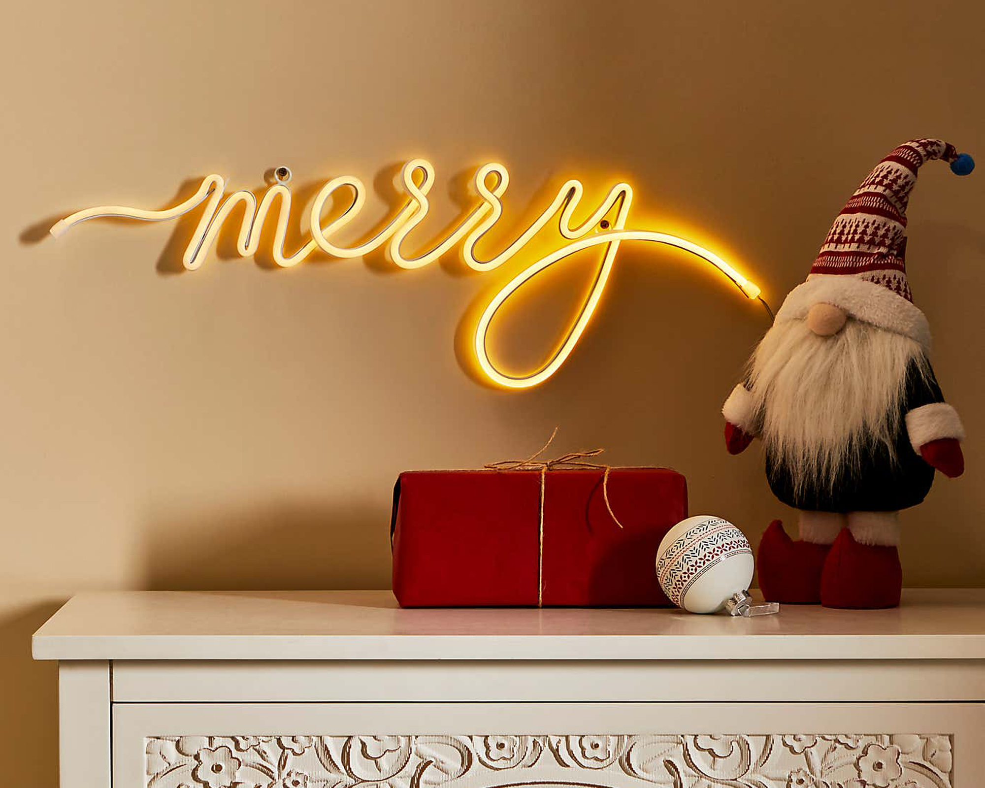 merry letter light sign on a chest of drawers with a Scandi Santa by dunelm