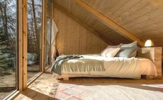 An inside view of a cabin showing a bed at Stedsans in the Woods — Hyltebruk