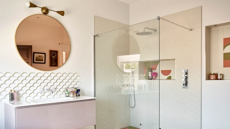 Pink bathroom with round copper mirror