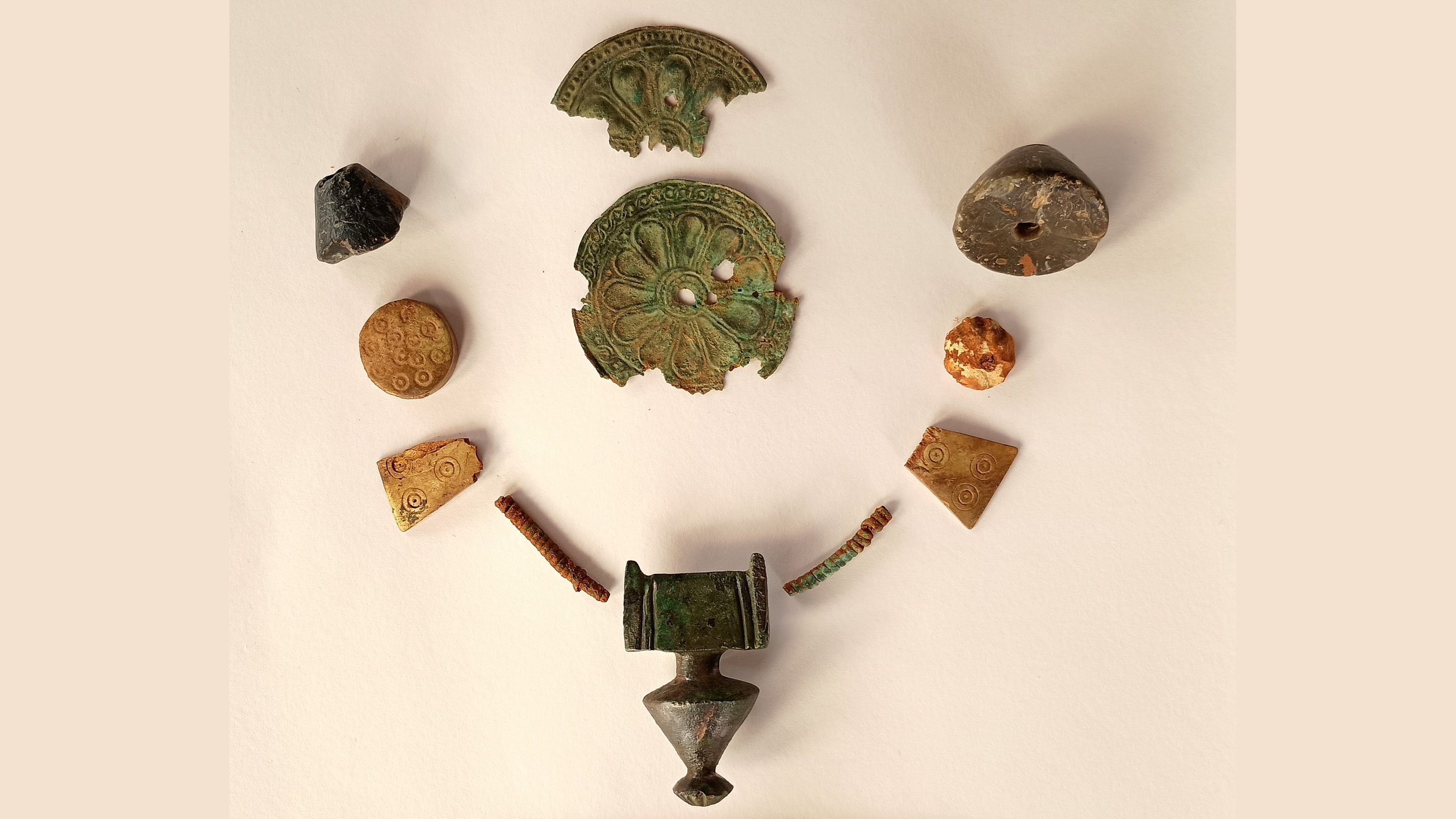 a set of different sized beads and bronze jewelry