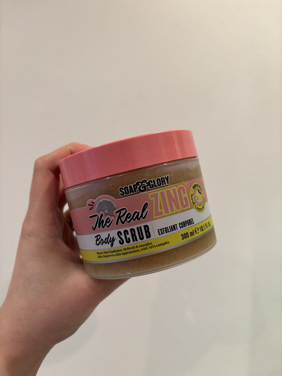 Mica Ricketts sosteniendo Soap & Glory The Real Zing Body Scrub