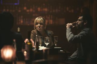 Jenna (Sheridan Smith) and Jack (Kelvin Fletcher) sit at a table in a pub. Jack is drinking from a glass and there are several other glasses of alcoholic drinks on the table