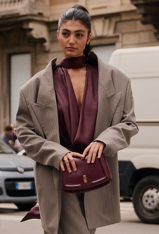 A woman wearing the wine red color trend during Milan Fashion Week spring/summer 2025.