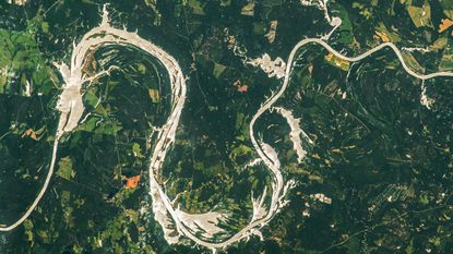 An astronaut photo of a golden river in the shape of a Chinese dragon