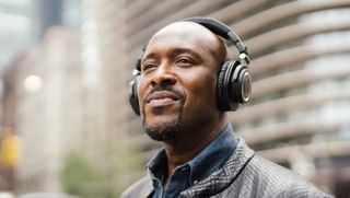 a smiling man wearing the audio-technica ath-m50xbt2 headphones