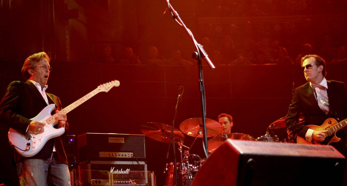 Eric Clapton plays a solo on a blue Strat as Joe Bonamassa looks on