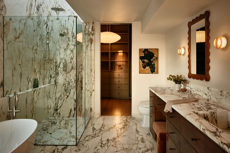 a white marble bathroom with the lights on