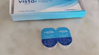 Image shows two GlassesUSA.com Vista plus contact lenses in packaging.