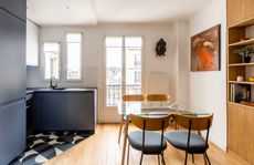 A small kitchen in a corner, within a large dining space