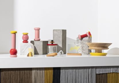 Collection of colourful kitchen accessories including pepper, salt and spice mills, a bottle opened, a magnetic photo holder, bowl and jar. 