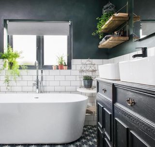 bathroom with white tiles on half wall and bathtub