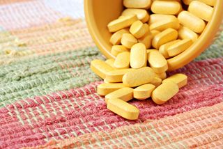 Vitamin B tablets spill from small dish
