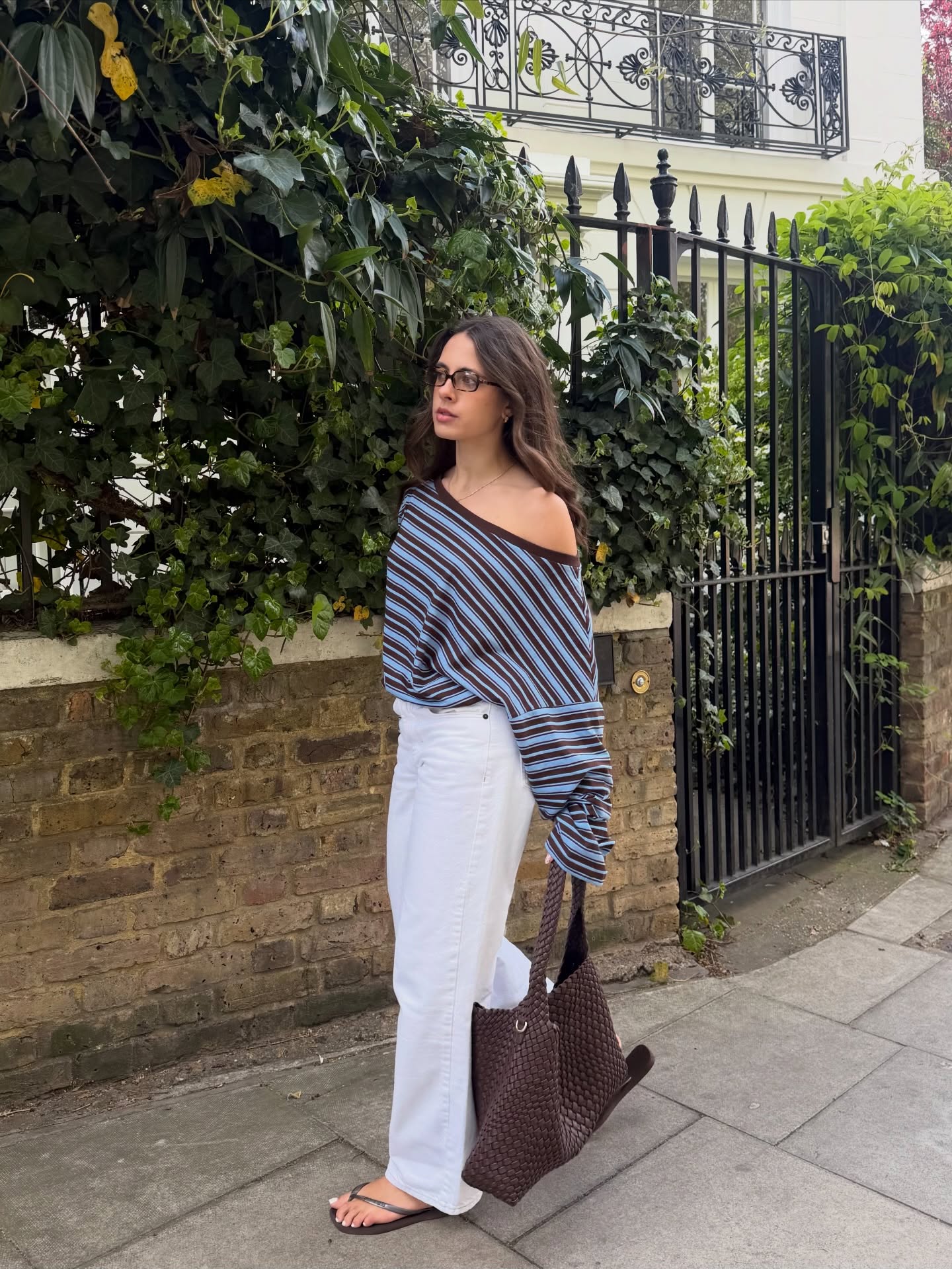 Tia Dewitt wears a stripey off the shoulder top with white linen trousers and flip flops as a summer styling hack 2026