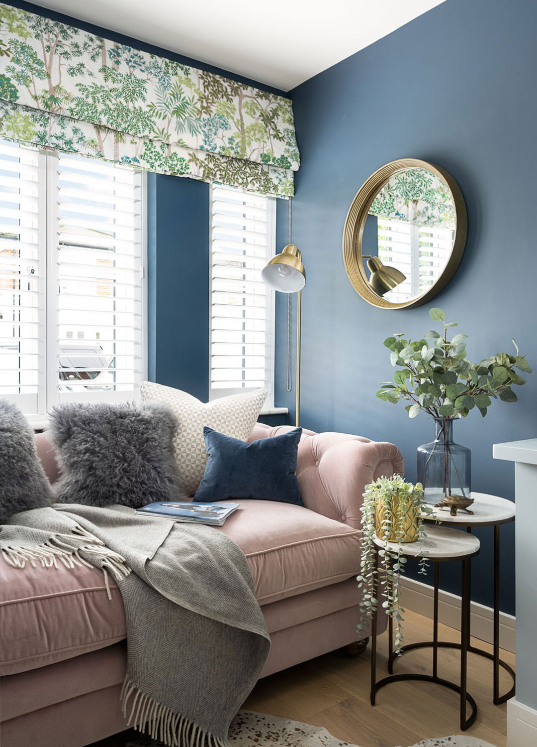 blue living room with pink velvet sofa