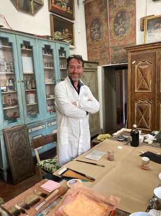 man in a white lab coat in a workshop