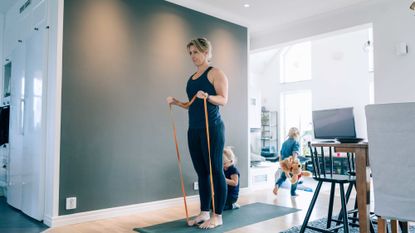 Woman exercising with resistance bands at home