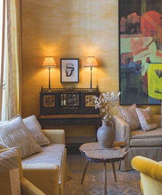 sitting area with yellow walls and two sofas against walls and coffee table