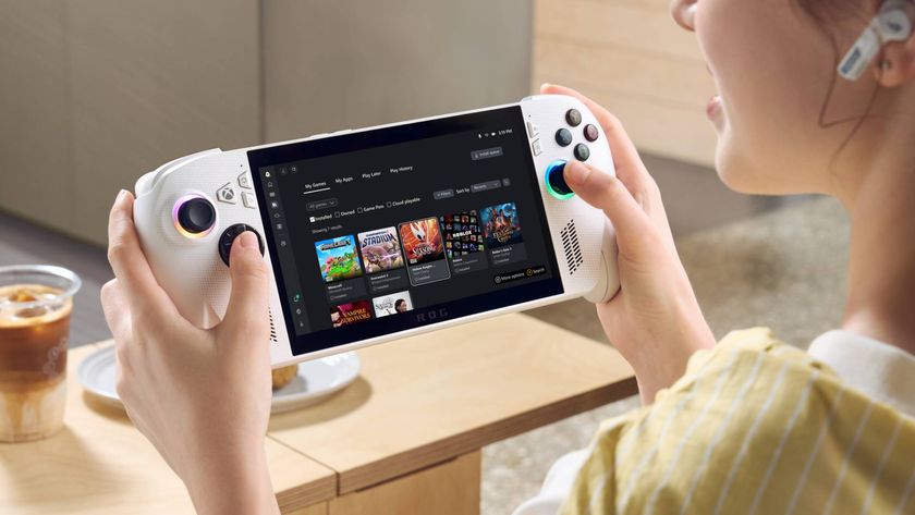 Player holding white ROG Xbox Ally X handheld with table in backdrop and iced coffee.