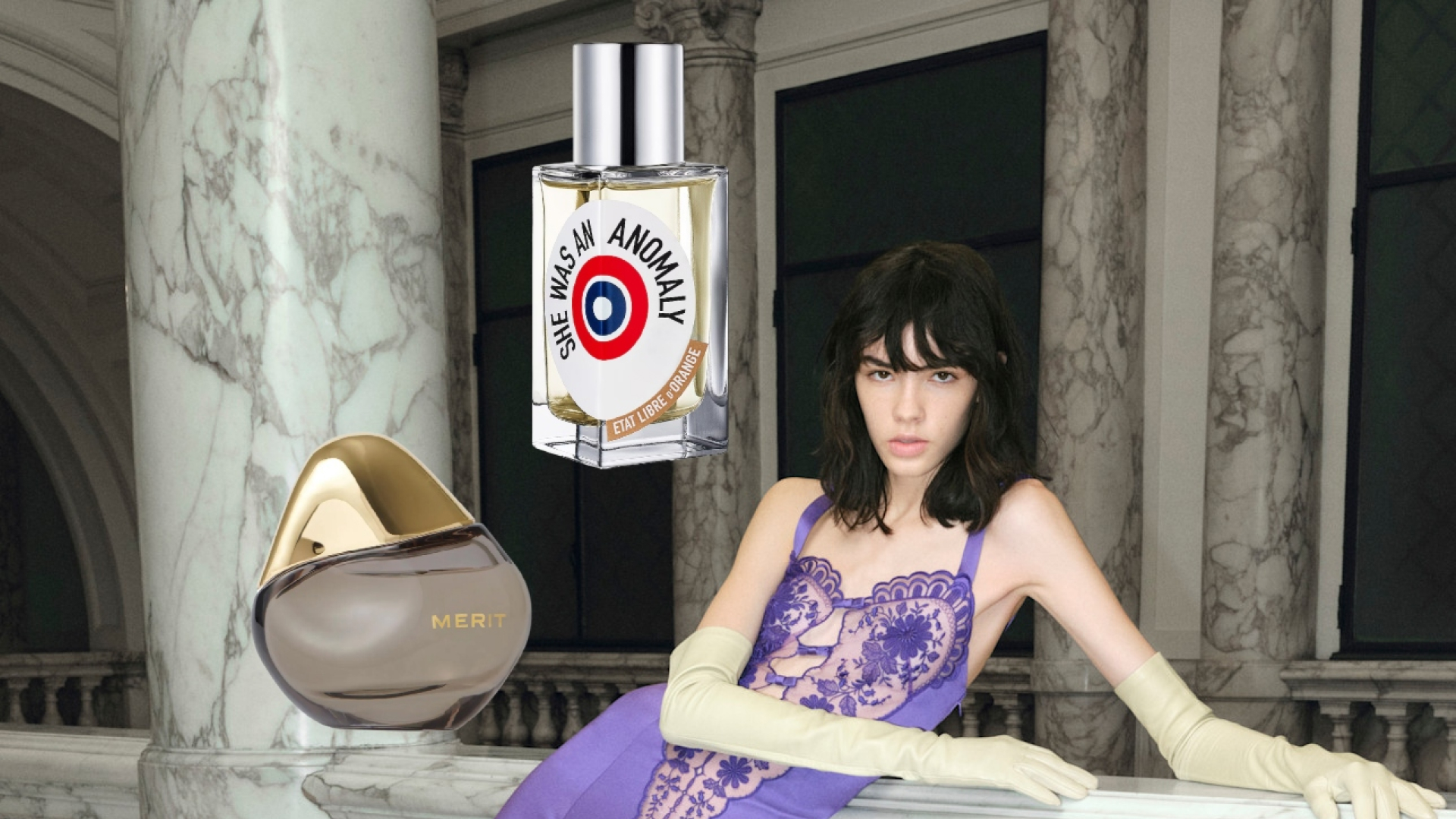 A model wearing a purple gown. She is surrounded by bottles of iris perfumes. 