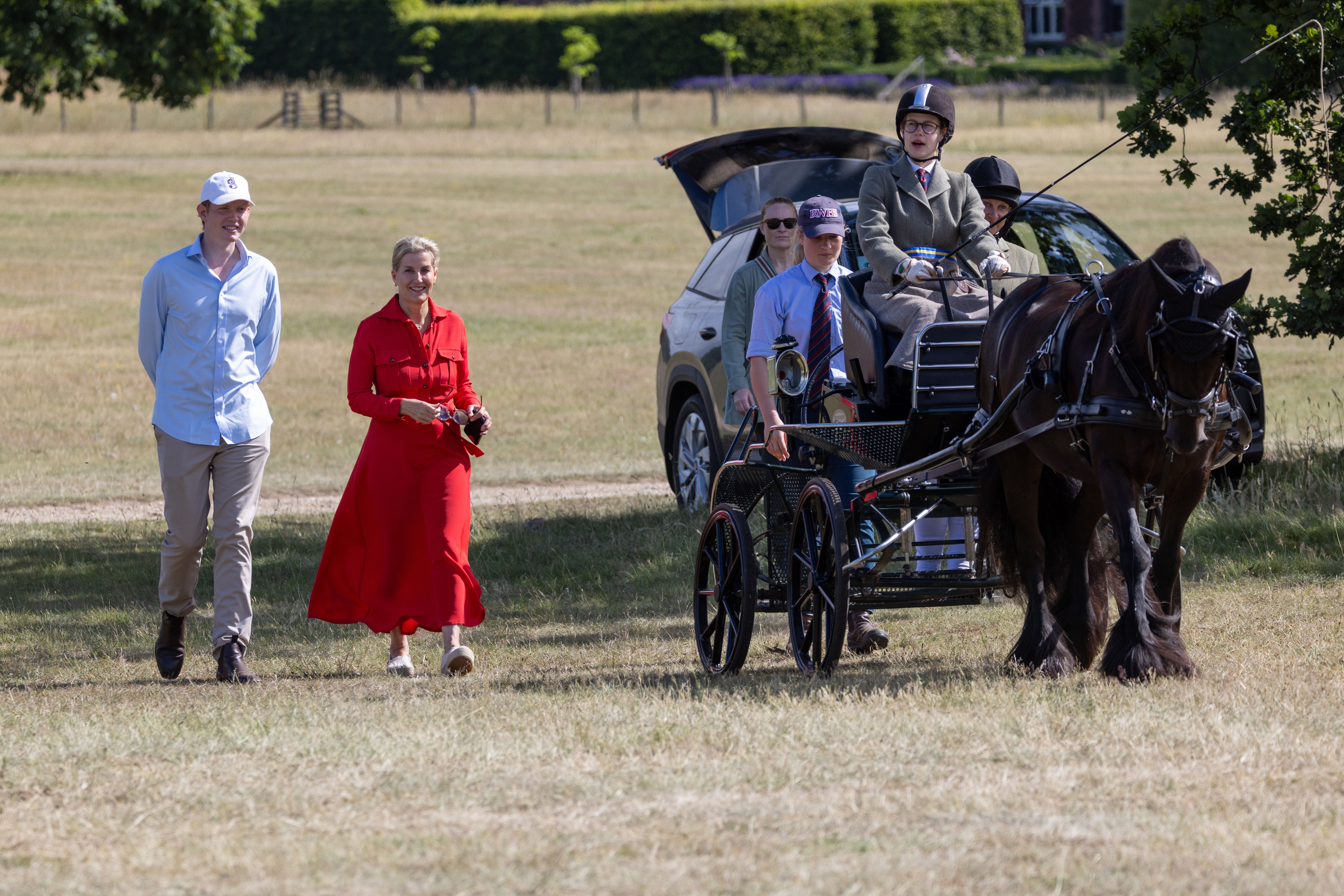 Felix da Silva-Clamp walking with Duchess Sophie next to Lady Louise, driving a horse-drawn carriage