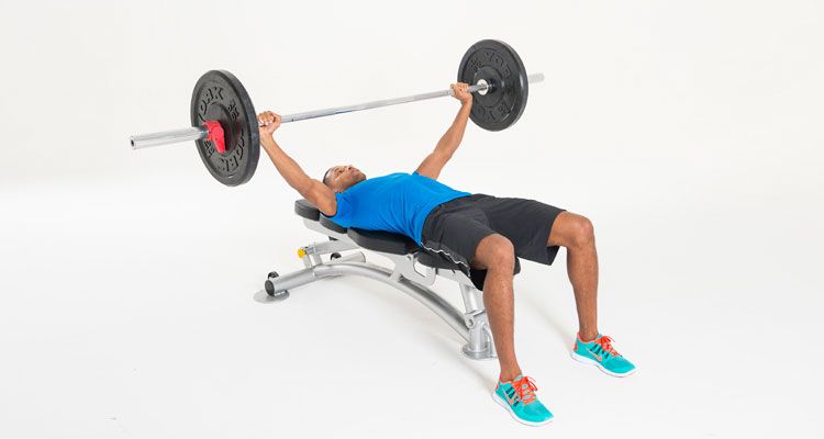 Man performs bench press, a pushing exercise