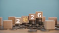 Blocks that say 2026 surrounded by scattered coins and stacks of coins.