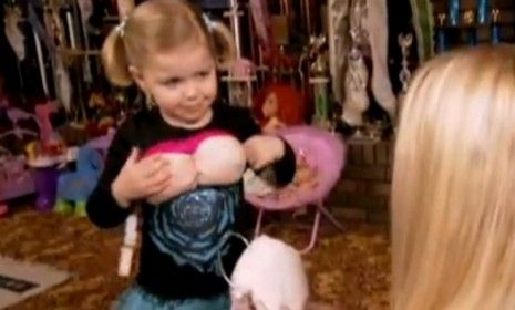 Madisyn Verst, 4, tries on fake boobs as part of her Dolly Parton costume, which was actually her mom&amp;#039;s from her own child pageant days.