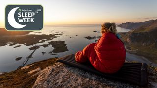 Woman sitting in sleeping bag watching sunset