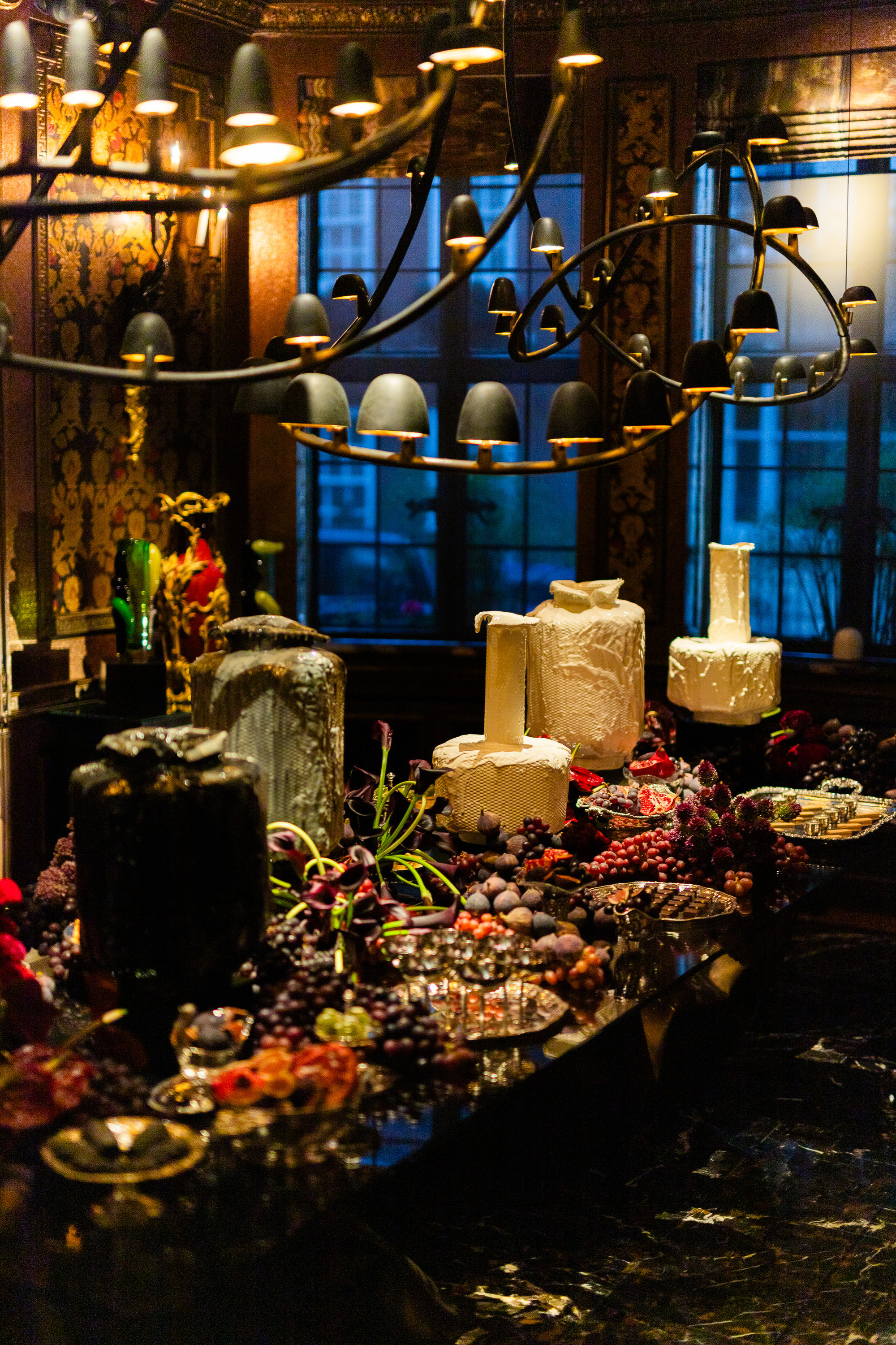 a grazing table with fruit and large cheeses