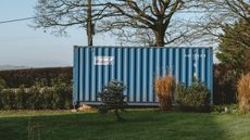 a blue container in a large garden