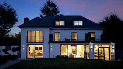 Securing a sliding glass door of an exterior of a house with Lutron lighting photographed at night 